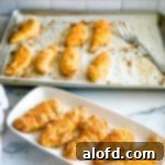 March Flavor Feast: Irresistible Dinner Ideas 15 A generous platter of golden Bisquick chicken tenders, with a baking sheet of more delicious tenders blurring in the background.