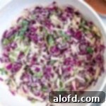 March Flavor Feast: Irresistible Dinner Ideas 30 An overhead shot of a generous serving of vibrant taco slaw in a large, pristine white bowl.