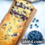 March Flavor Feast: Irresistible Dinner Ideas 35 A slice of delectable blueberry pound cake resting on a cutting board, accompanied by a bowl of fresh blueberries.