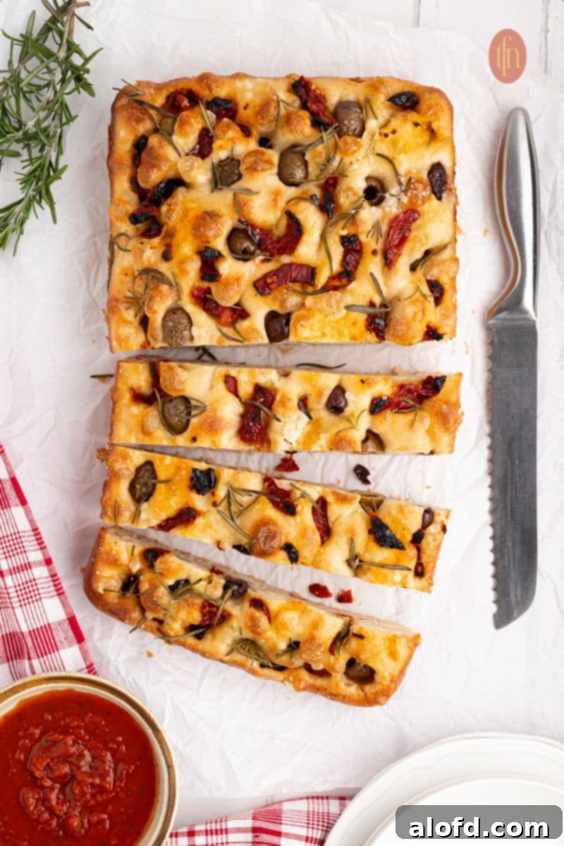 Beautifully sliced baked sourdough focaccia bread, showcasing its airy texture and golden crust.