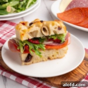 A slice of golden sourdough focaccia bread on a white plate.