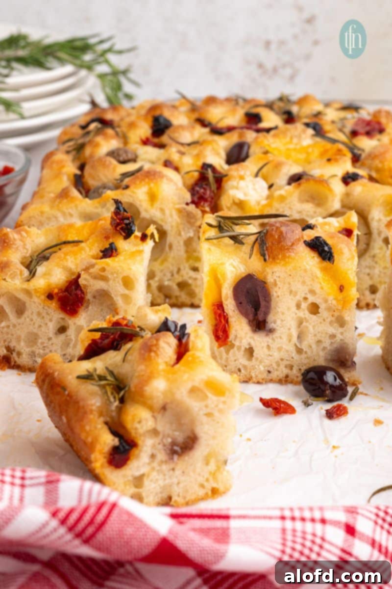 Slices of freshly baked sourdough focaccia bread on a baking pan, ready to be served.