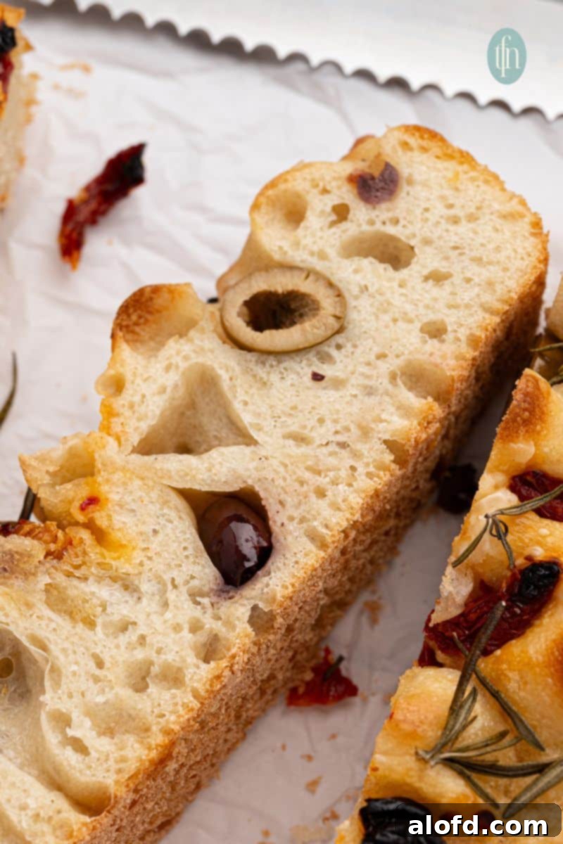 A golden-brown slice of sourdough focaccia, showcasing its inviting texture.