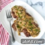 Country style steak with mushroom gravy on a platter, a savory crock pot beef meal.