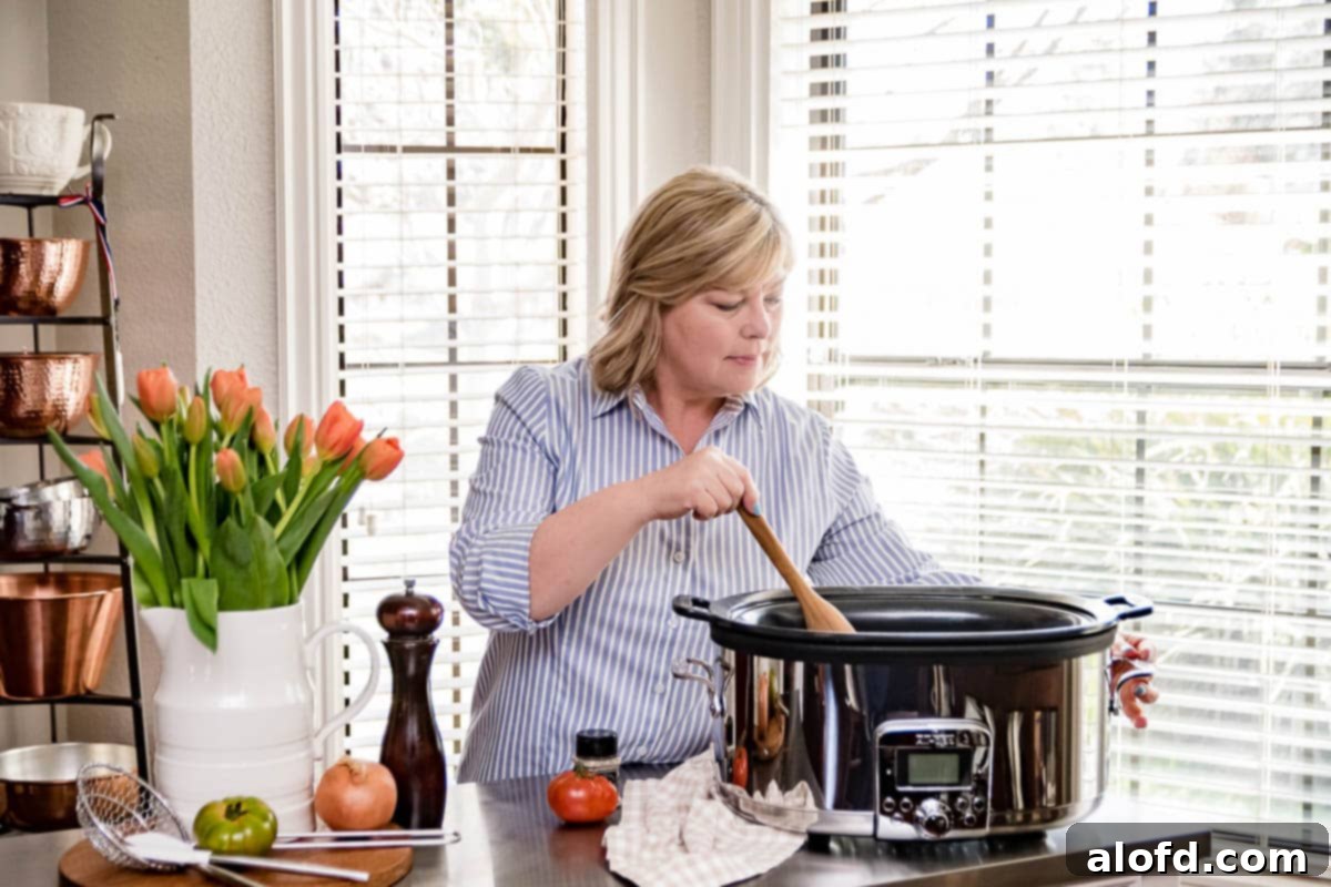 A woman holding a wooden spoon while cooking a meal with a slow cooker, emphasizing hands-free cooking.
