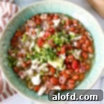 a square photo of a green bowl of slow cooker pinto beans with bacon, a comforting and flavorful dish.