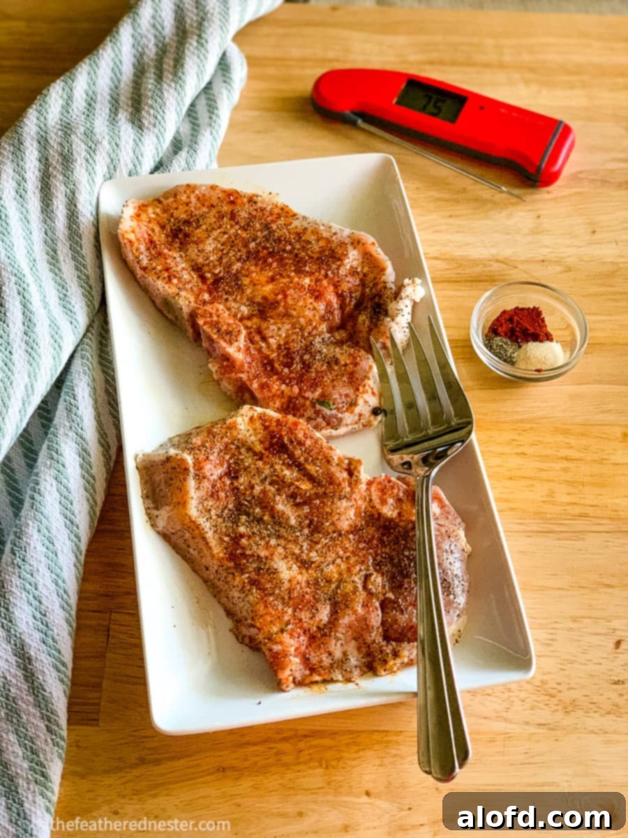 Succulent Buttermilk Pork Chops 9 Seasoned pork chops on a plate, ready for cooking.