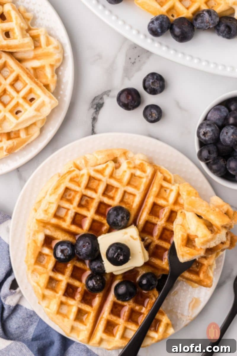 Fluffy Golden Bisquick Waffles 3 Waffles on a white plate.