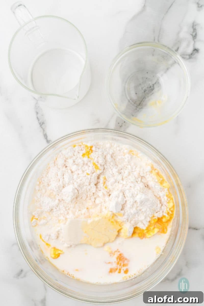 Fluffy Golden Bisquick Waffles 8 A mixture of flour and liquid ingredients in a glass bowl.