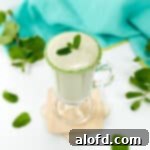 St Patricks Day Feast Ideas 5 A vibrant green Protein Shamrock Shake in a glass with a straw.