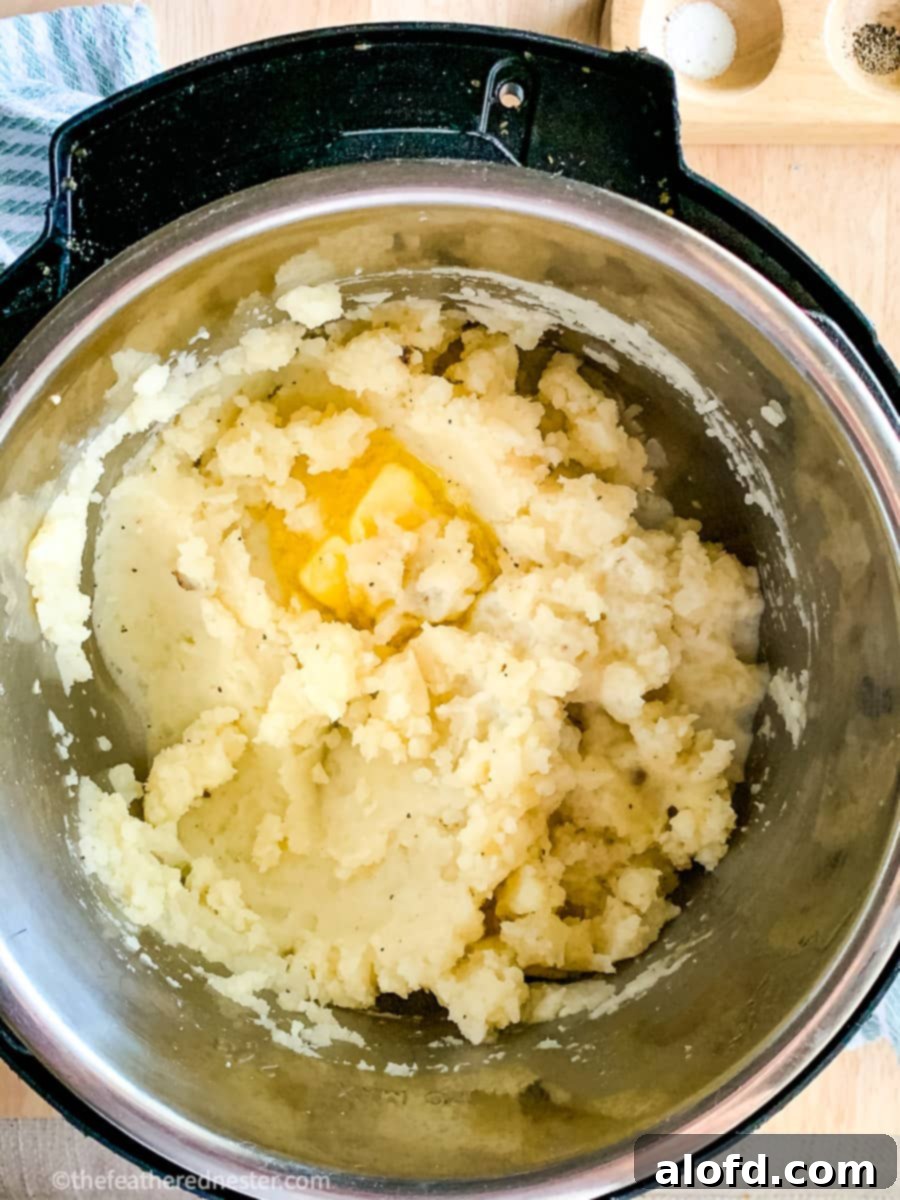 Foolproof Instant Pot No-Drain Mash 5 Instant Pot mashed potatoes with butter melting over them in the pressure cooker.