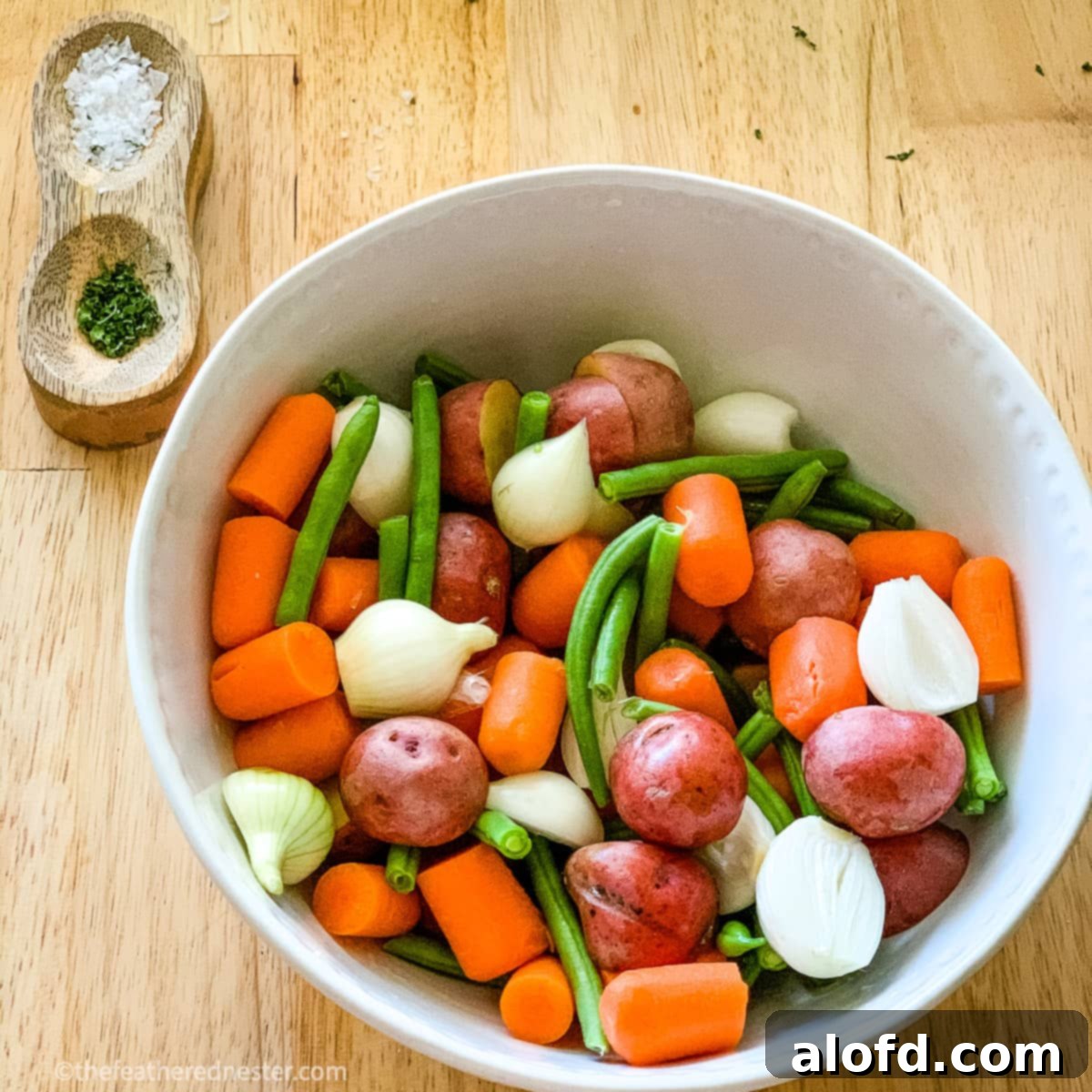 a bowl of carrots, potatoes, green beans, and onions ready for balsamic marinade