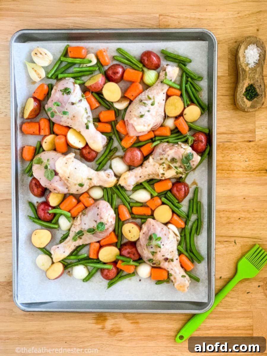 prepared one pan chicken drumsticks with potatoes and veggies ready to go into the oven