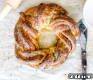 Savory bread appetizer on parchment paper with a serving utensil.
