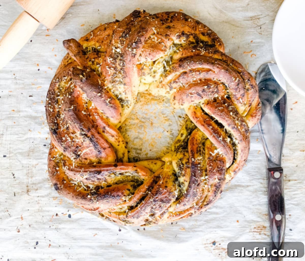 Savory bread appetizer on parchment paper with a serving utensil.