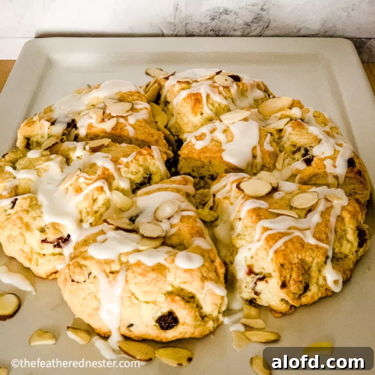 Cranberry almond scones recipe displayed on a platter, ready to serve with their almond glaze.