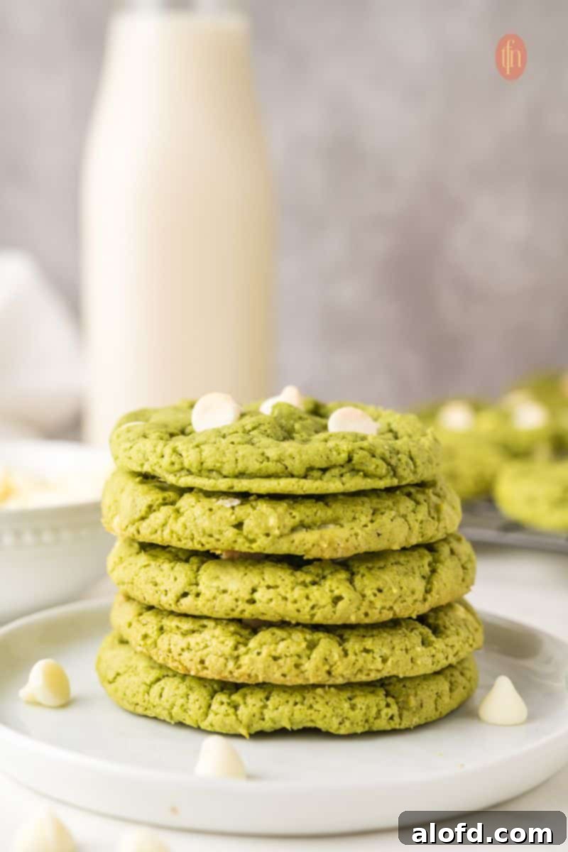 Vibrant Matcha White Chocolate Cookies 2 A plate of stacked green matcha white chocolate cookies, showcasing their vibrant color and inviting texture.