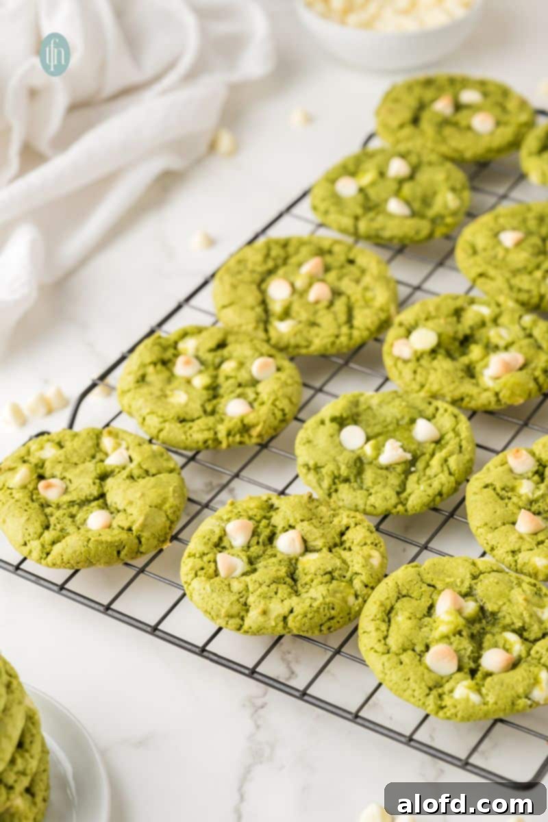 Vibrant Matcha White Chocolate Cookies 14 Freshly baked green matcha white chocolate cookies cooling on a wire rack, ready to be enjoyed.