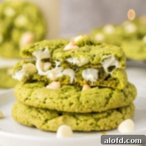 Vibrant Matcha White Chocolate Cookies 17 A plate of stacked green matcha white chocolate cookies, showcasing their vibrant color and inviting texture.