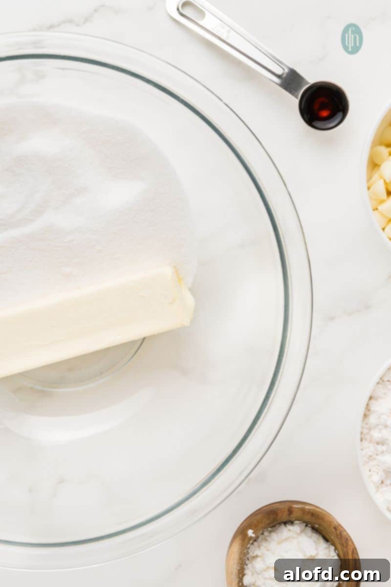 Vibrant Matcha White Chocolate Cookies 7 A bowl containing creamed butter and sugar, with a spoon of vanilla extract being added.