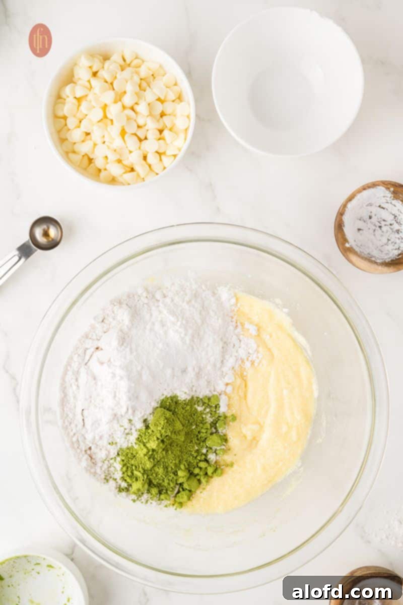 Vibrant Matcha White Chocolate Cookies 9 A bowl filled with dry ingredients including flour, matcha powder, and leavening agents.