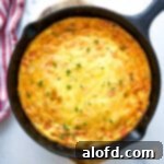 A savory egg frittata beautifully presented in a rustic cast iron skillet, ready to be served.