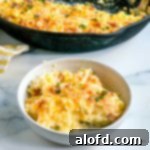 A golden breakfast casserole with hash browns, ham, and cheese, scooped into a bowl and perfectly ready to serve.