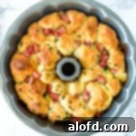 A golden-brown bundt pan filled with freshly baked savory monkey bread, ready to be pulled apart.