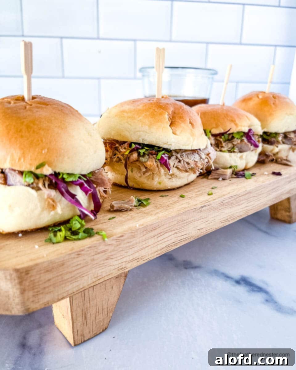 Delicious Dutch oven pulled pork sliders, generously topped with a vibrant coleslaw and artfully arranged, ready for serving.