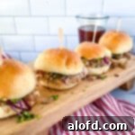 Succulent Dutch oven pulled pork, generously topped with a crisp cabbage slaw and served on soft buns, ready to be enjoyed.