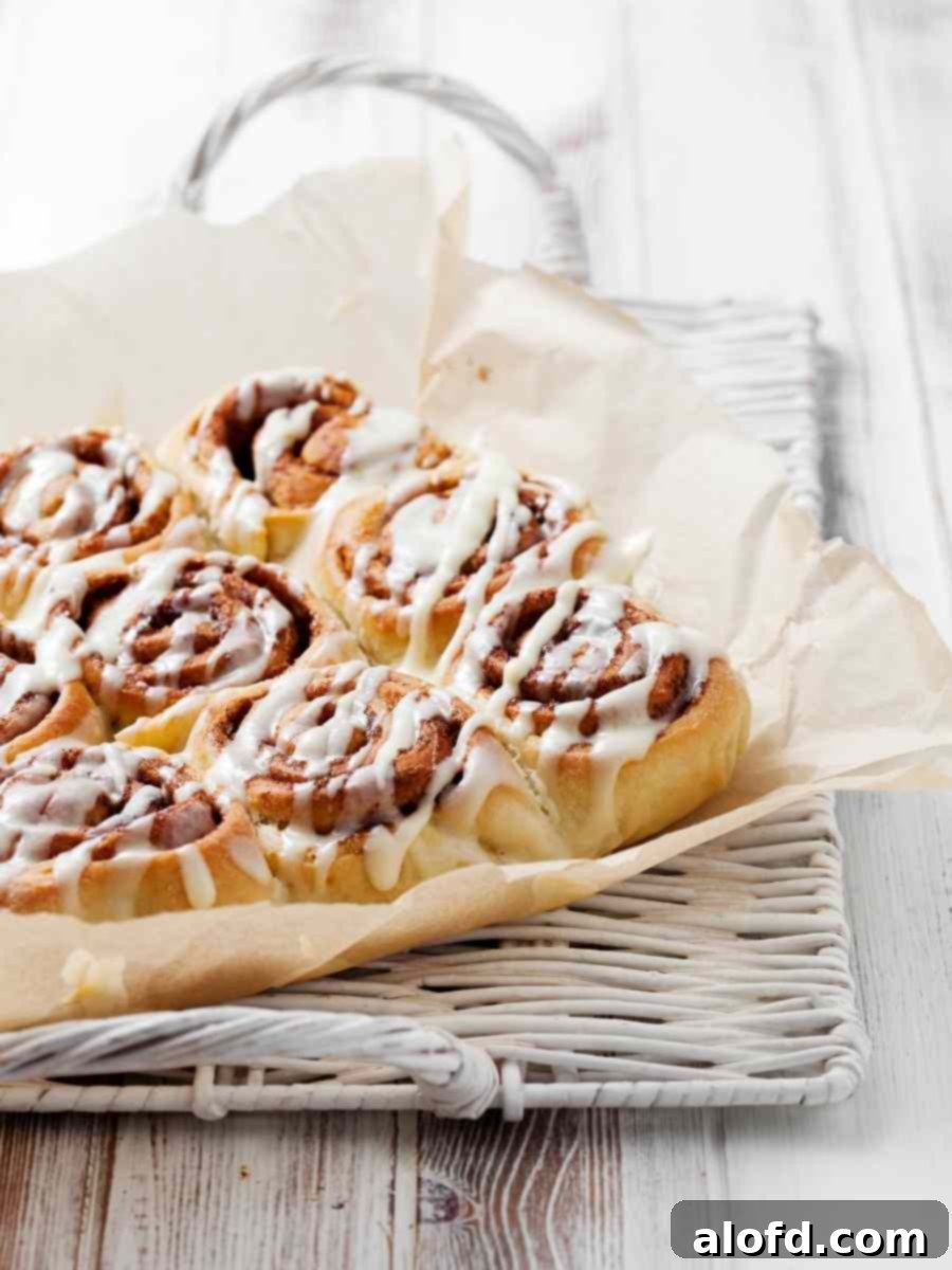 A baking sheet generously filled with freshly frosted cinnamon rolls, ready to be enjoyed.