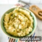 A vibrant green bowl brimming with fluffy red mashed potatoes, beautifully garnished and ready to serve.