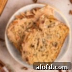 Two exquisite slices of carrot cake loaf elegantly arranged on a round plate, invitingly ready to be enjoyed.