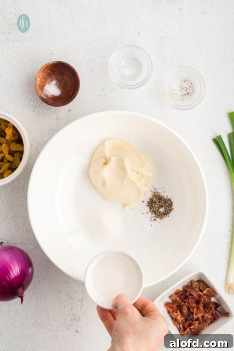 Ingredients for the dressing, including mayonnaise, sugar, and vinegar, in separate bowls before mixing.