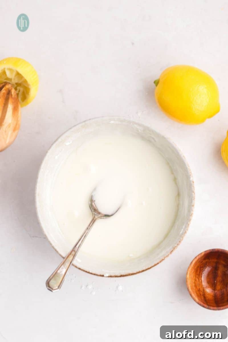 Lemon Blueberry Bliss Bites 17 Lemon glaze in a bowl with a spoon, showing perfect consistency.