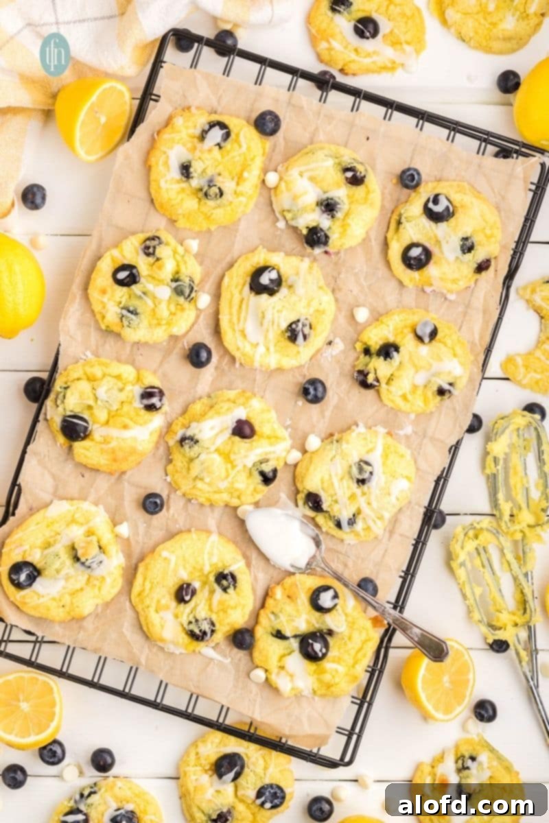 Lemon Blueberry Bliss Bites 19 Glazed cookies cooling on a wire rack over parchment paper.