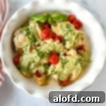 Light and Vibrant Spring Dinners 18 a white plate of Instant Pot Pesto Chicken and a striped red cloth at the side.