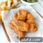 Light and Vibrant Spring Dinners 22 shake and bake chicken tenders placed on a parchment paper on top of a wood serving plate.