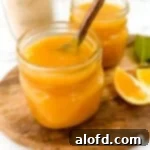 Light and Vibrant Spring Dinners 28 Two jars of meyer lemon curd with spoon on top of a wooden board with slices of lemon.