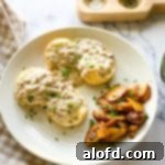 Light and Vibrant Spring Dinners 8 a plate of sausage gravy and biscuits with potatoes and a checked napkin and salt and pepper.