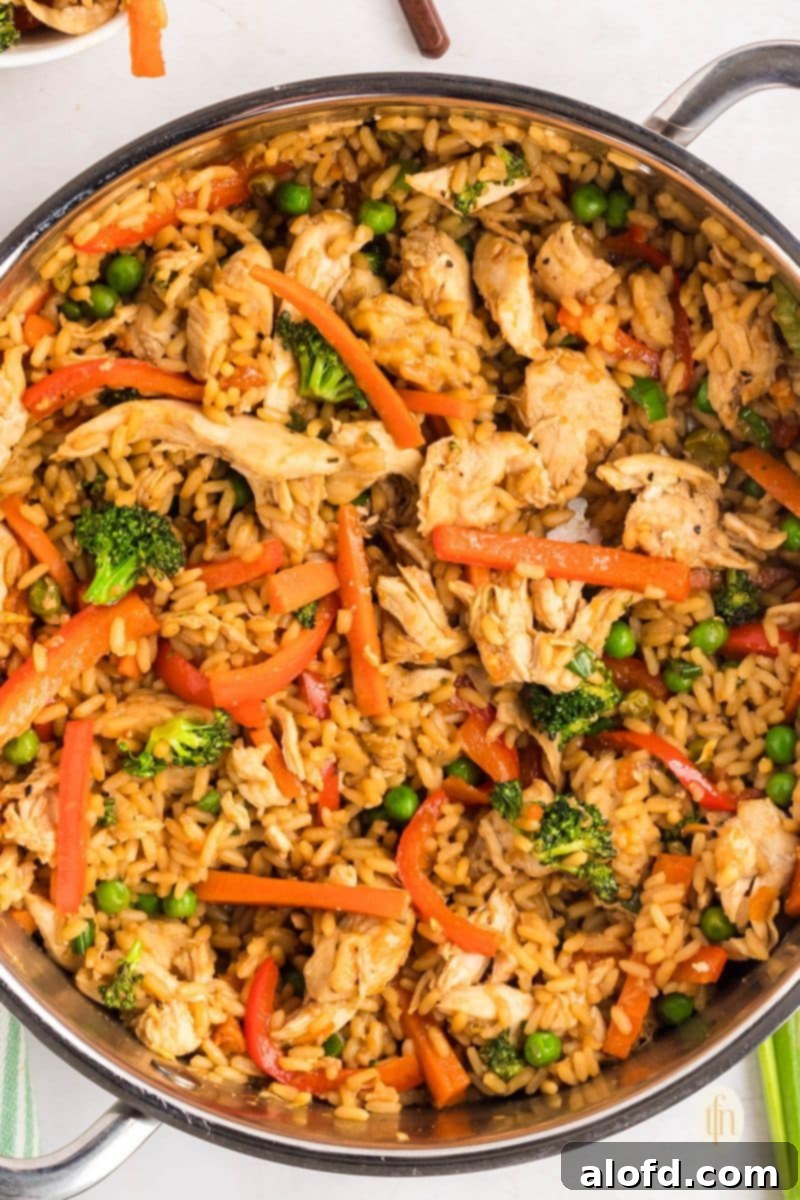 A large pan filled with the vibrant ingredients of the chicken and rice bowl, ready to be served.