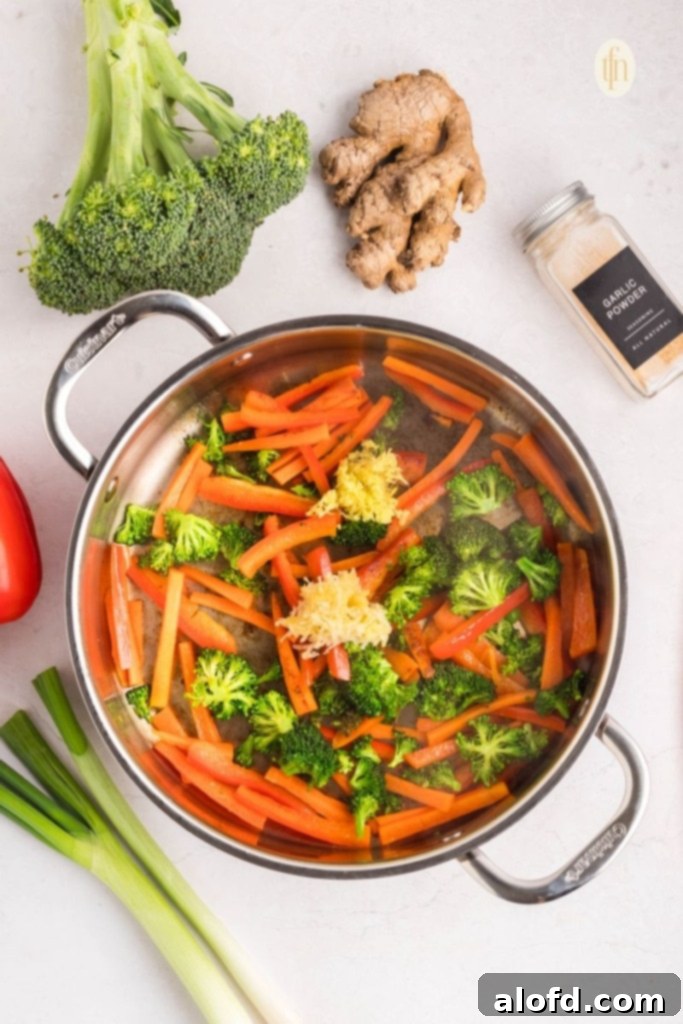 Vibrant stir-fried vegetables cooking in a large pan.