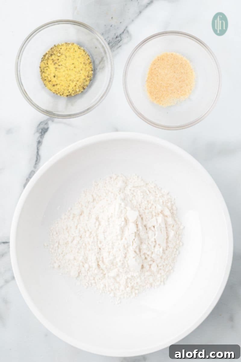 Zesty Lemon Chicken Orzo Pasta 6 A small bowl containing a dry mixture of flour, lemon pepper seasoning, and garlic powder, perfectly prepped for coating chicken.