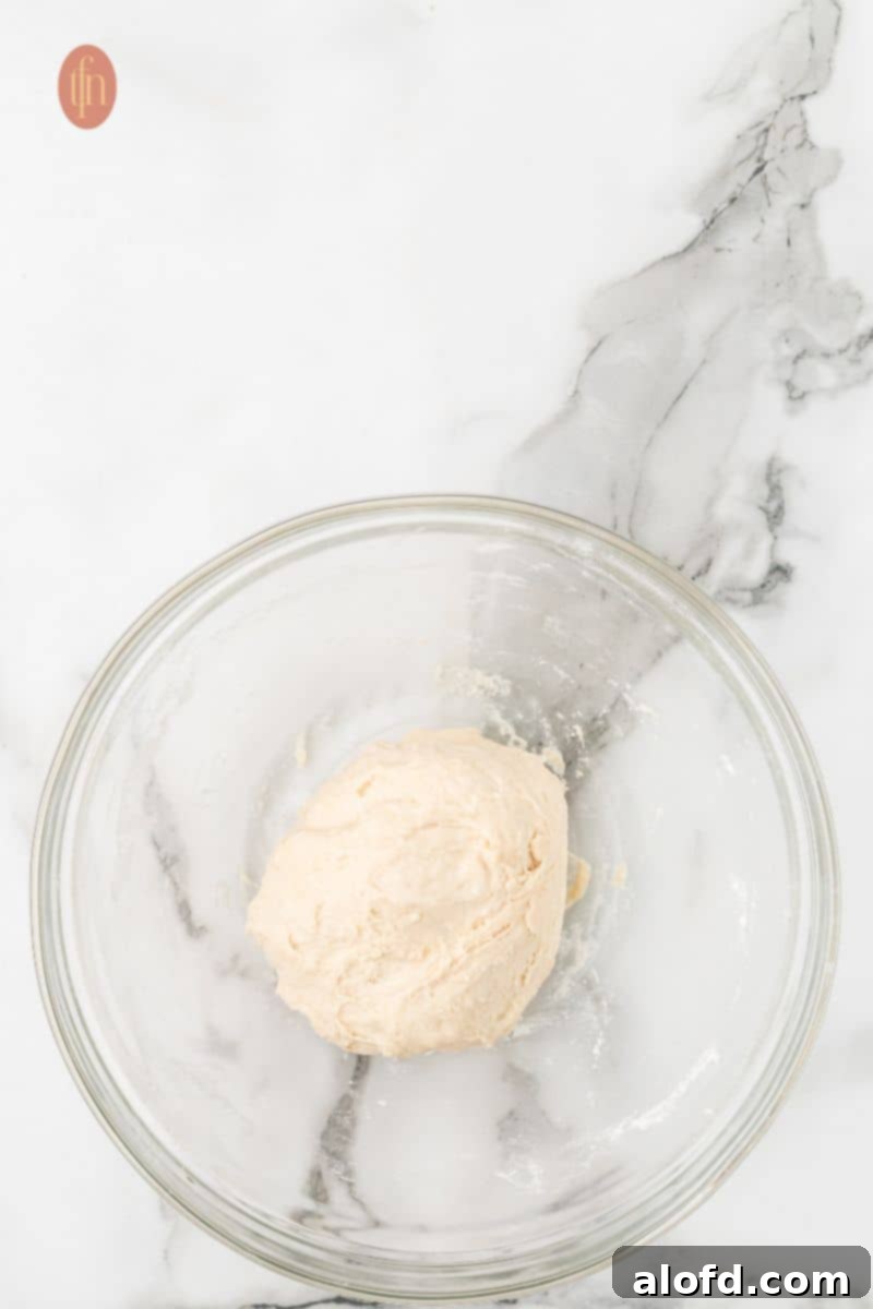 Artisan Sourdough English Muffin Bread 12 A well-developed, smooth dough resting in a bowl after being stretched and folded.
