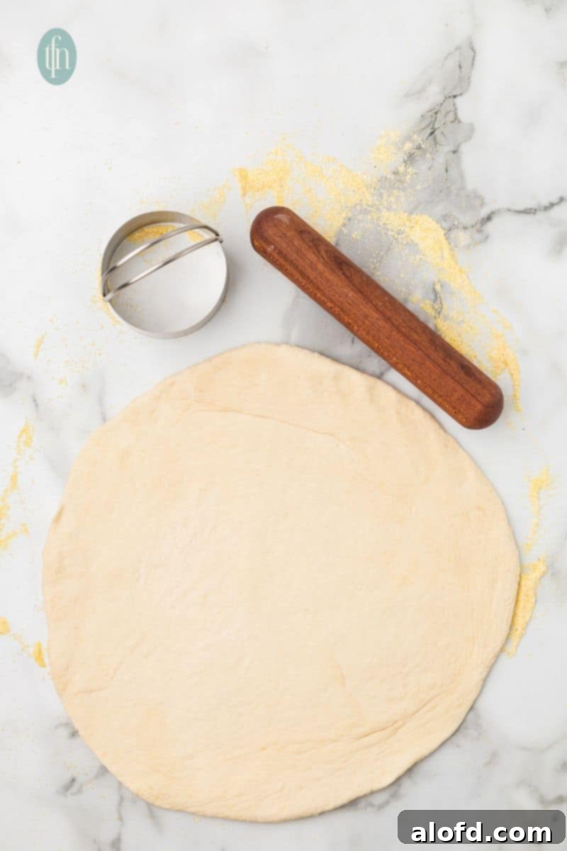 Artisan Sourdough English Muffin Bread 15 Rolled out dough with a cookie cutter in place, demonstrating how to cut uniform English muffins.