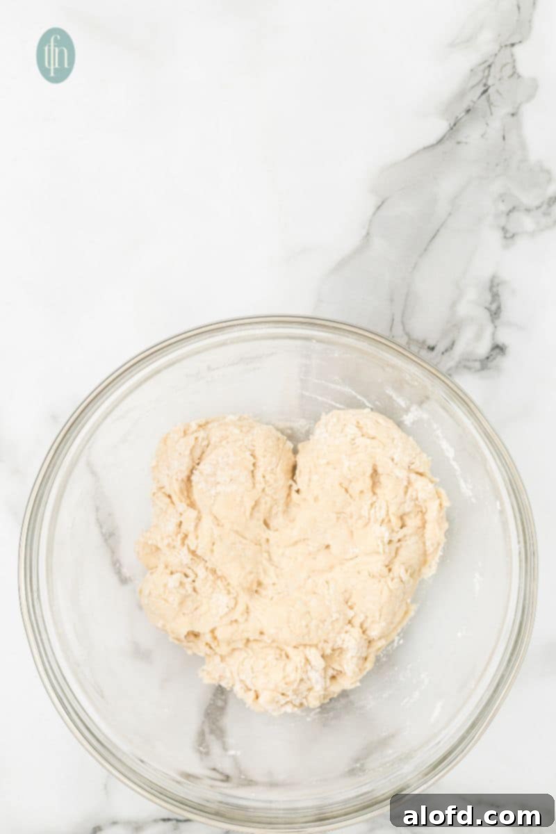 Artisan Sourdough English Muffin Bread 10 A bowl of shaggy, newly mixed dough, indicating the initial stage of gluten development.