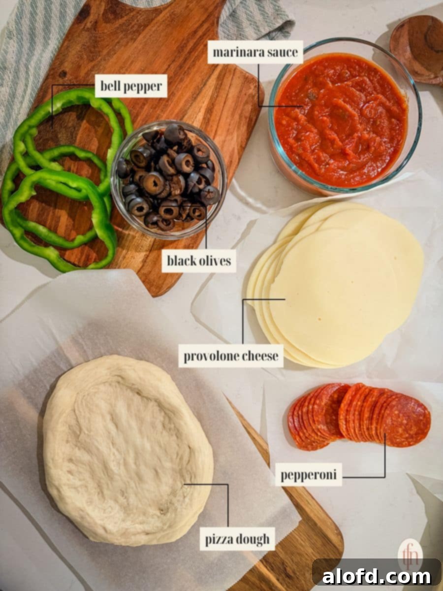 Monster Mash Pizza 4 An overhead shot of the ingredients for Halloween pizzas with each item labeled. The labels point to a round of pizza dough, a bowl of marinara sauce, sliced bell pepper, sliced black olives, rounds of provolone cheese, and a stack of pepperoni.