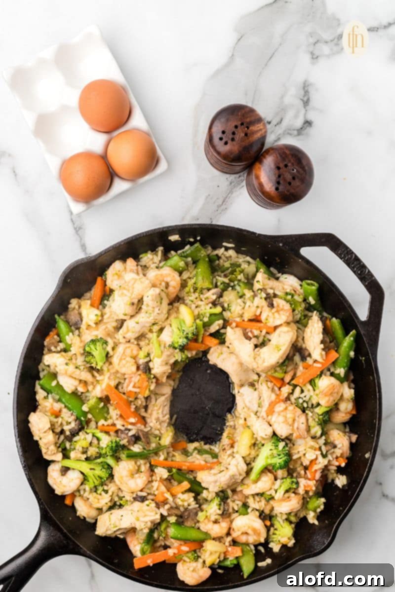 Surf and Turf Fried Rice 13 Creating a new well in the fried rice to add eggs for scrambling.