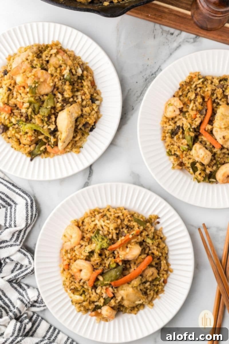 Surf and Turf Fried Rice 3 Three individual plates of shrimp and chicken fried rice, perfectly portioned and ready for a family meal.