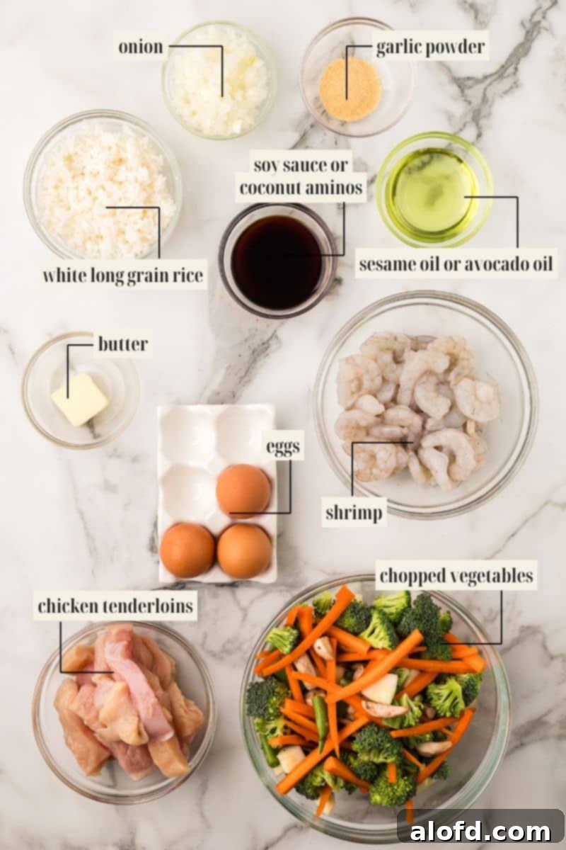 Surf and Turf Fried Rice 4 A selection of fresh ingredients laid out, including various vegetables, chicken, shrimp, oil, and spices, labeled for making fried rice.